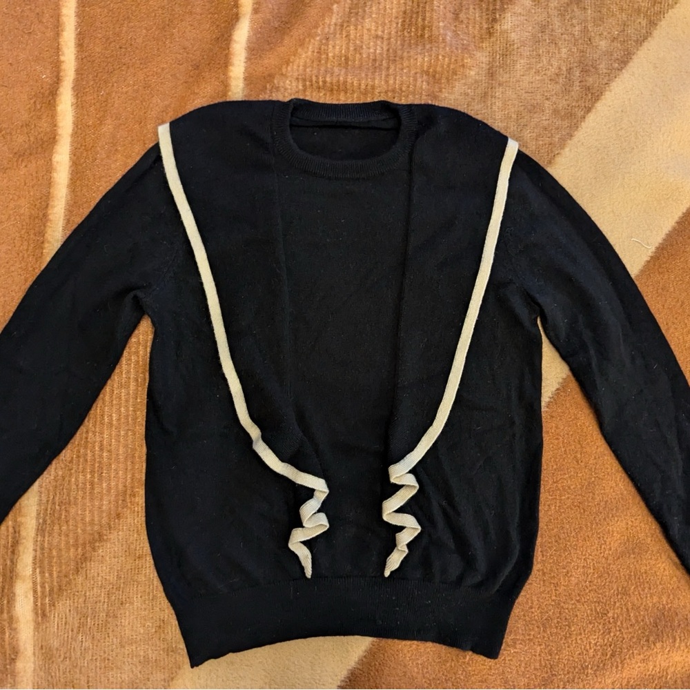 100% cashmere black sweater with ruffle details and white trim
